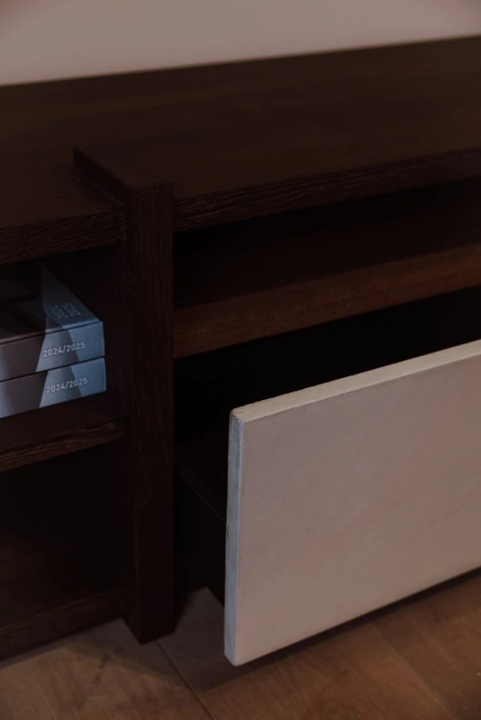 Detail van de open vakken en stonelook lade van de Masculin TV-kast